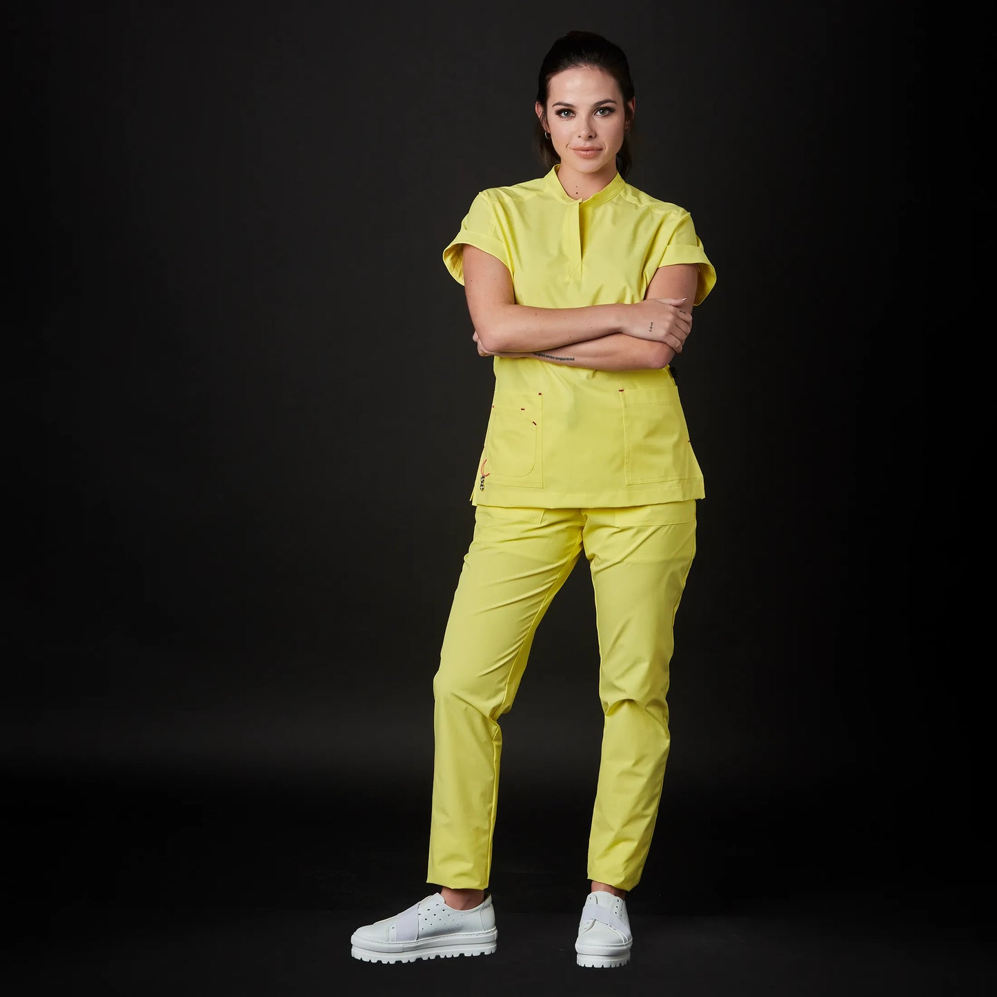 Immagine di una Medica o Dottoressa che indossa una Divisa Sanitaria Giallo Canarino, modello Phantom, della marca Gallantdale, specializzata in abbigliamento sanitario.