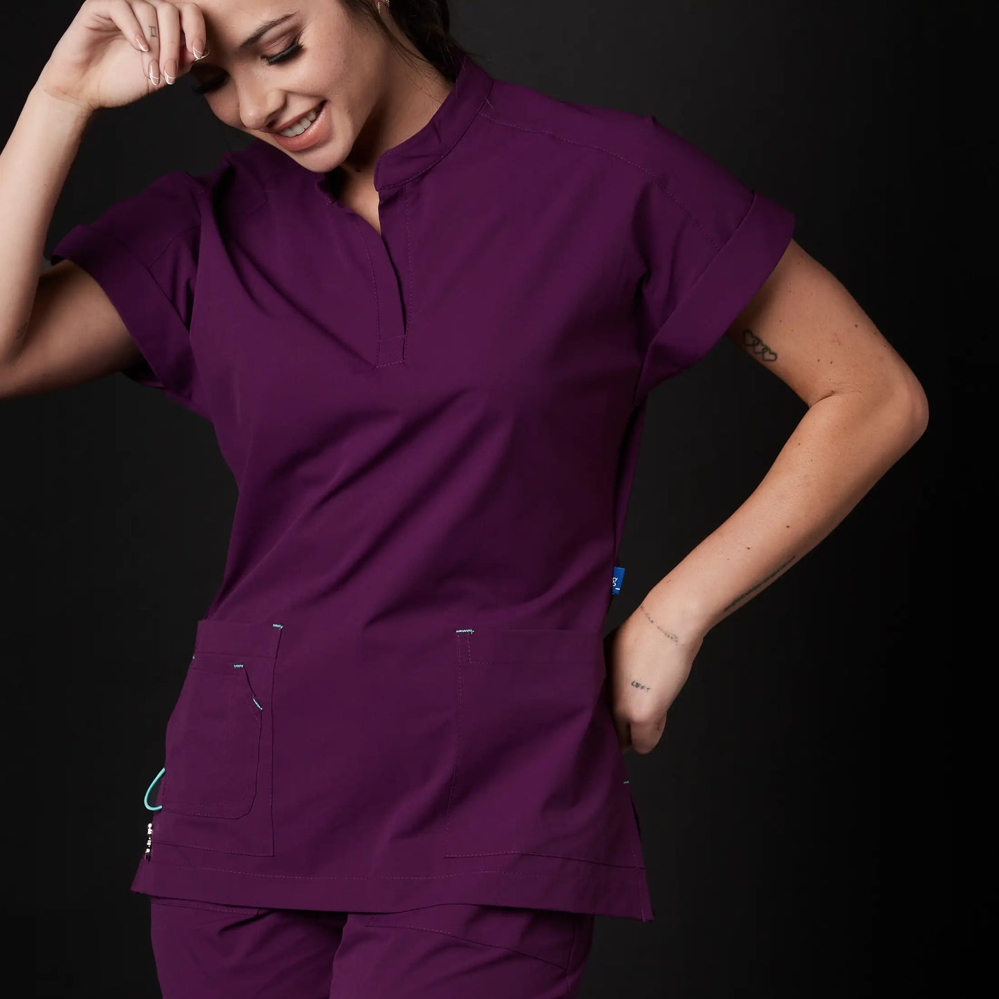 Immagine di una Medica o Dottoressa che indossa una Divisa Sanitaria Fucsia, modello Phantom, della marca Gallantdale, specializzata in abbigliamento sanitario.