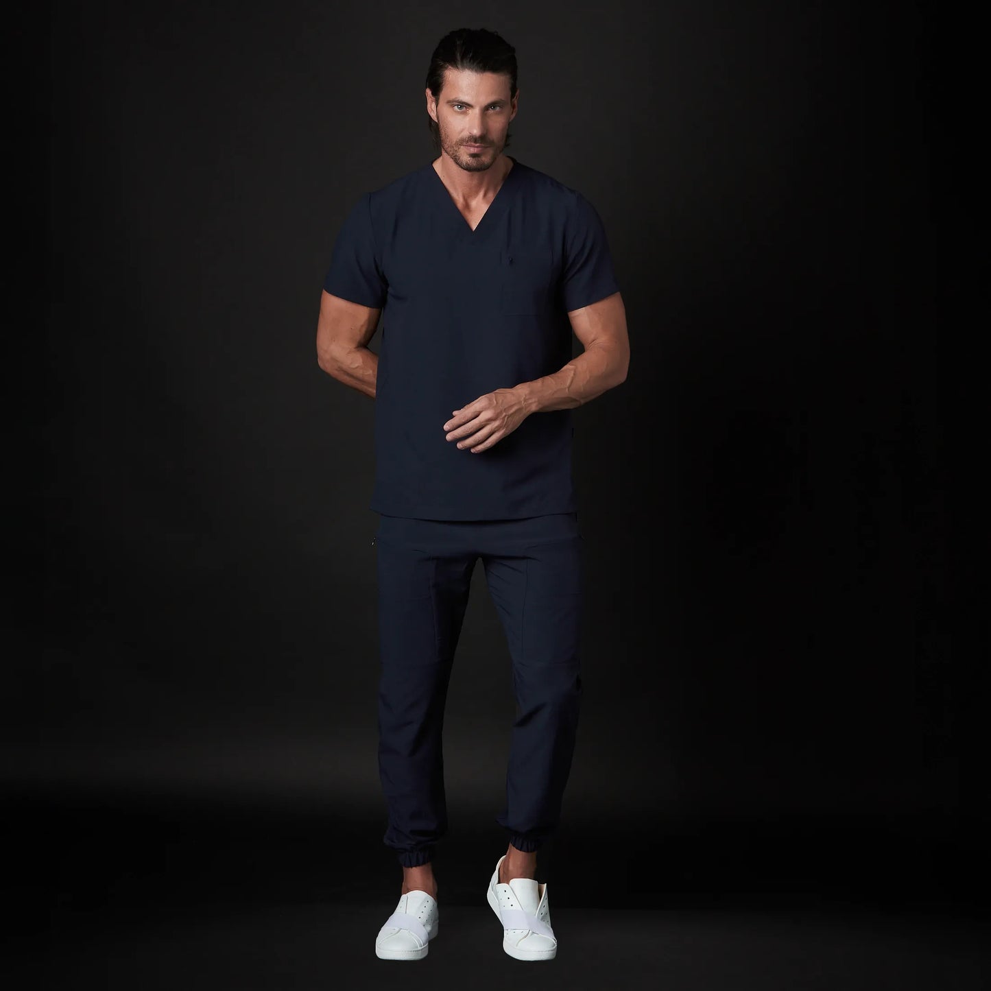 Immagine di un Medico o Dottore che indossa una Divisa Sanitaria Blu Marino, modello Urs, della marca Gallantdale, specializzata in abbigliamento sanitario.